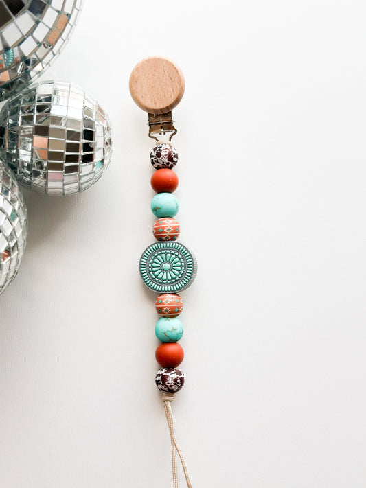 The turquoise junkie Pacifier Clip